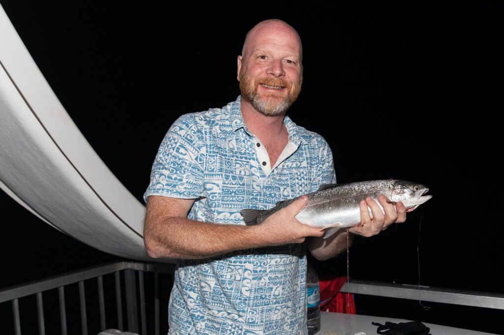 Happy man proudly holding fresh caught Kokanee Salmon