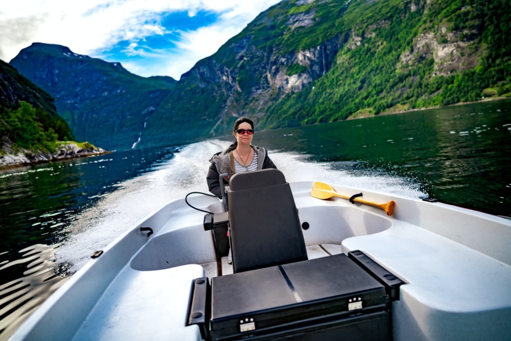 Woman driving a motor boat. Geiranger fjord, Beautiful Nature No