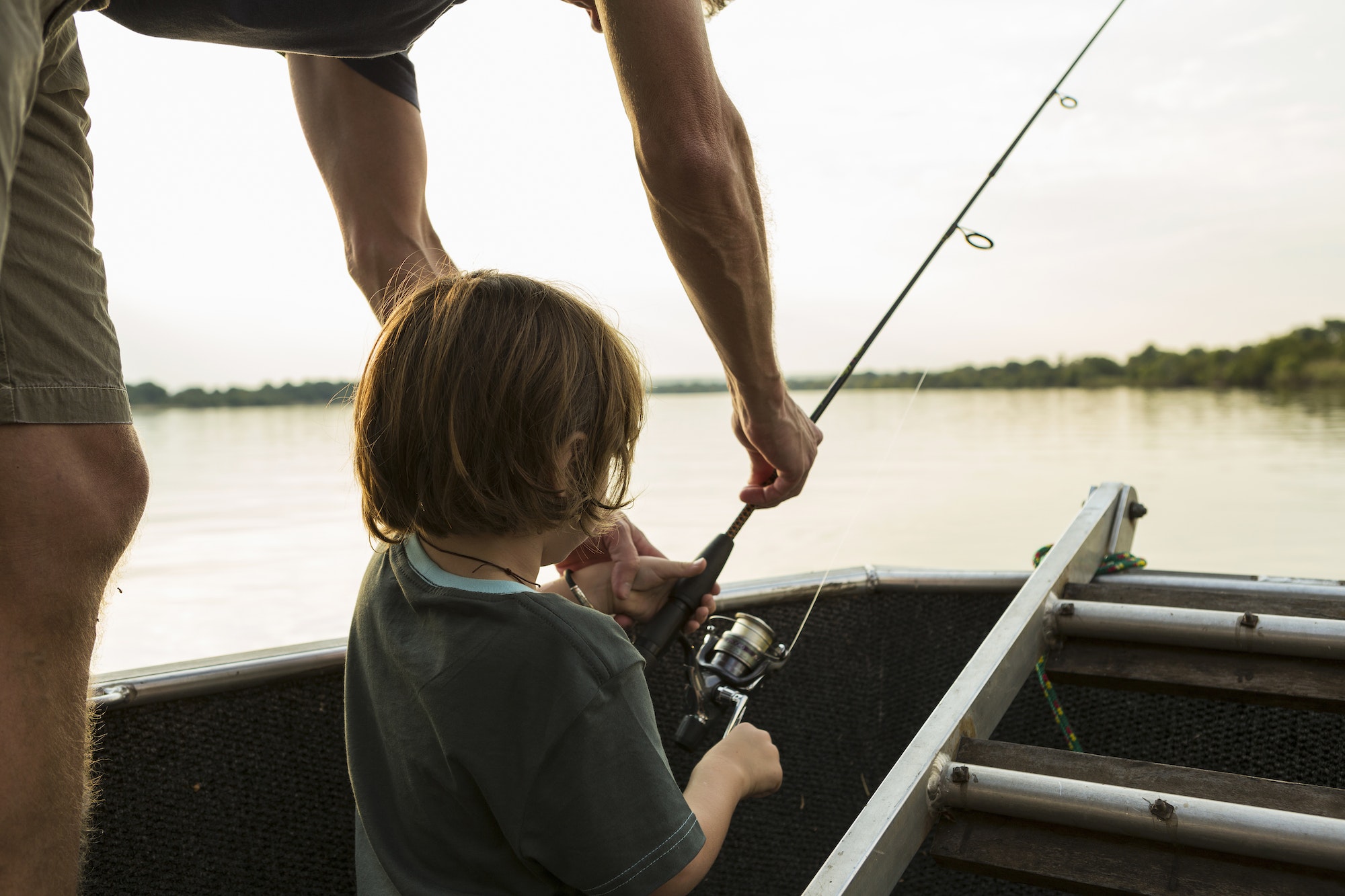 A five-year-old boy fishing from a boat