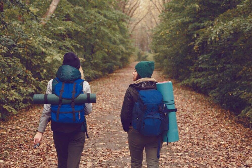 Girlfriend traveler with backpacks went hiking in the woods.