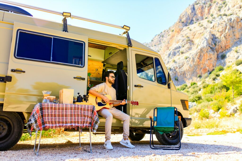 young indian man vacation travel RV, holiday trip in motorhome in mountain