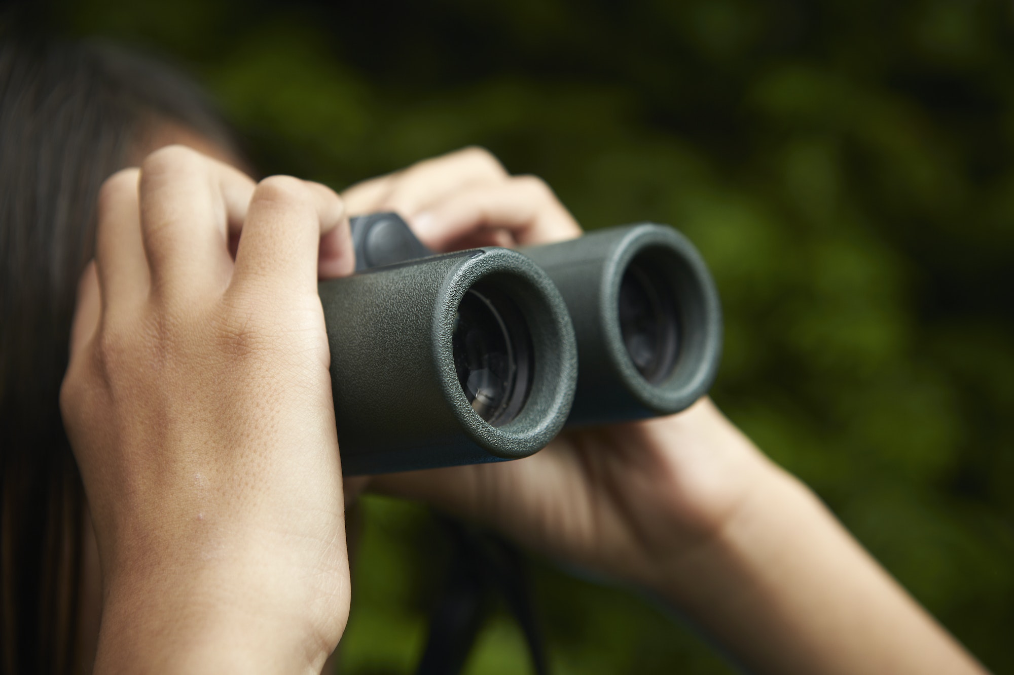 A young girl with bird watching binoculars.