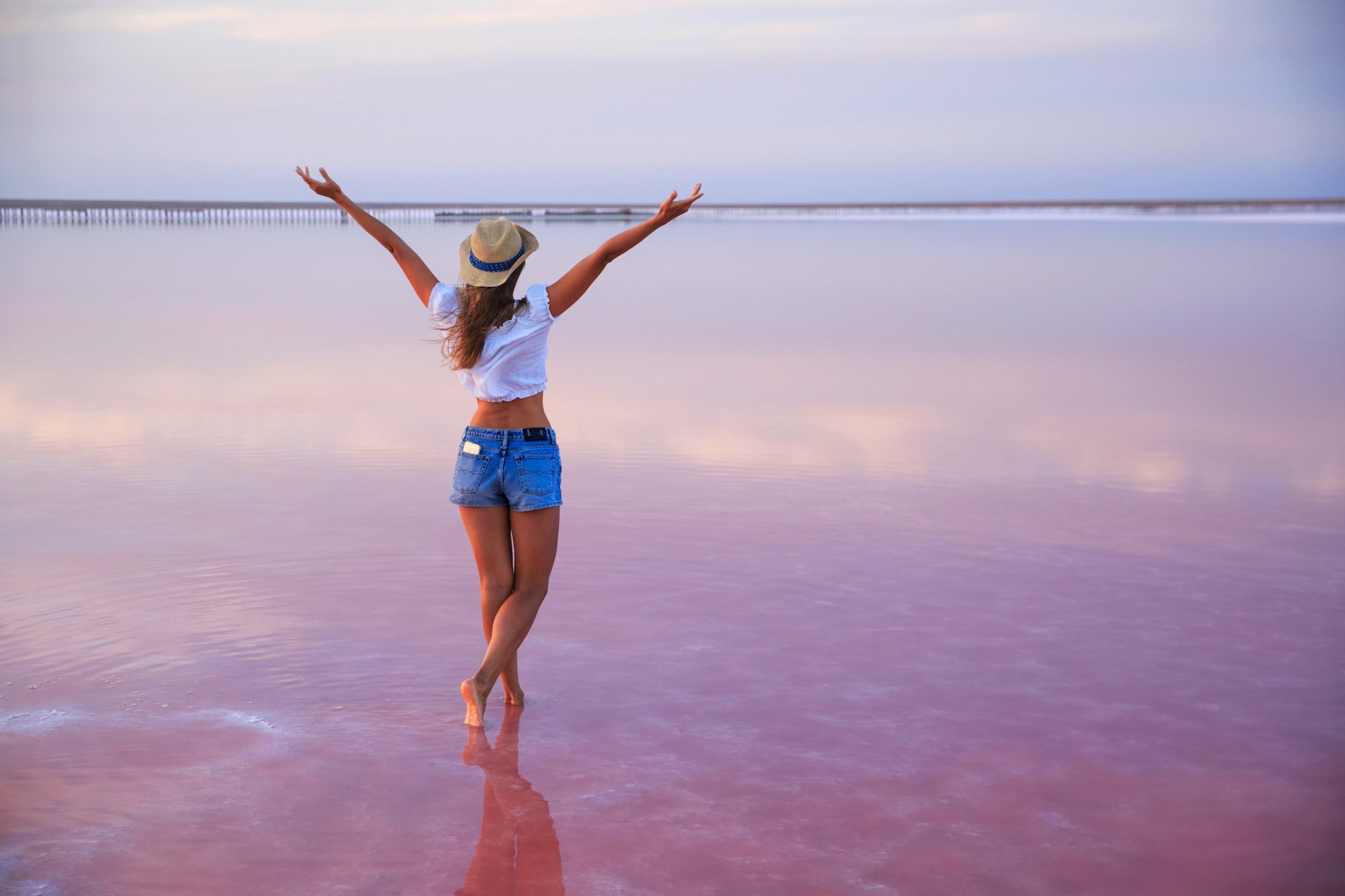 Happy young women walking on pink lake. Freedom. Travel. Adventure
