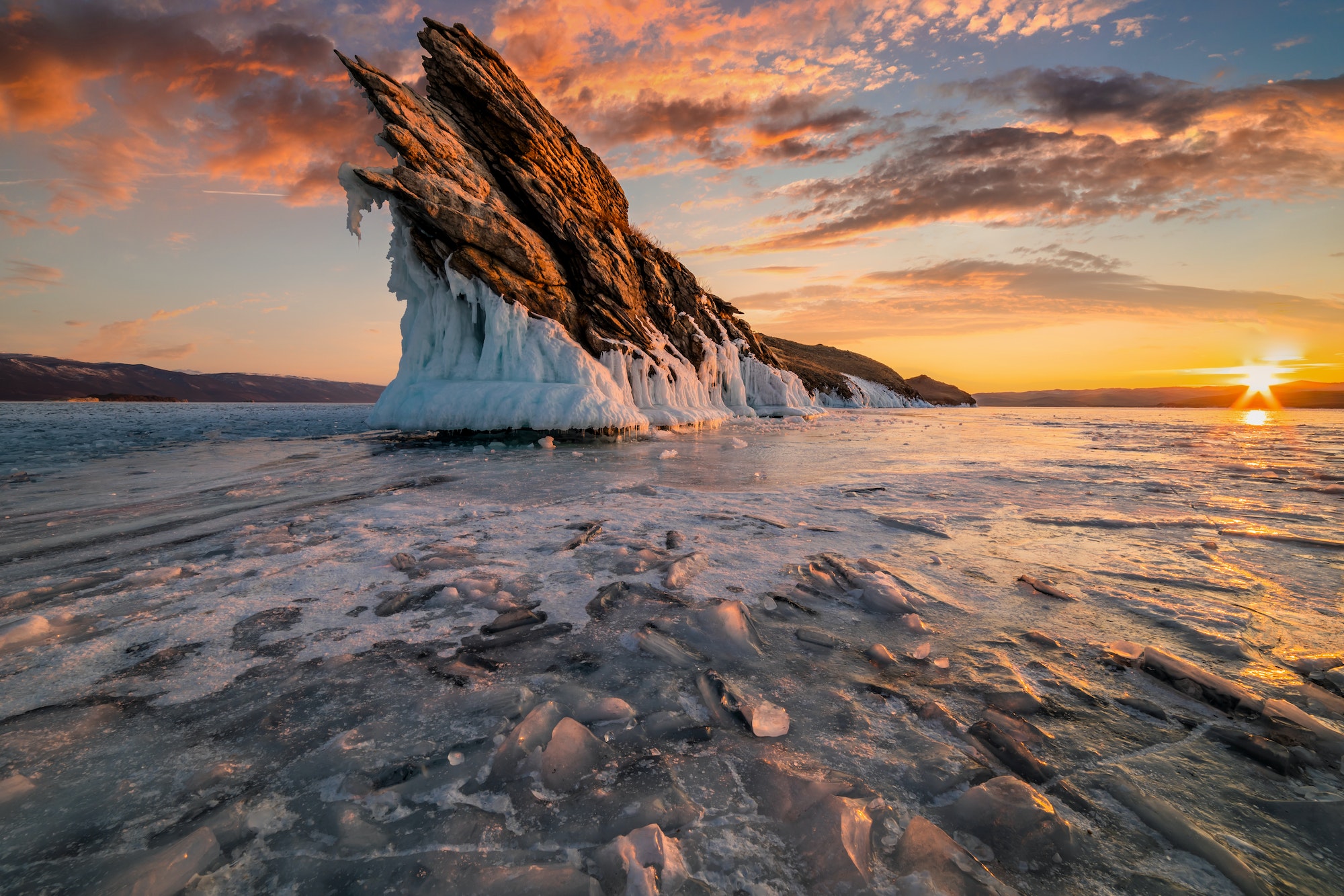 Rock on Lake Baikal in winter at dawn. Winter travel in Russia