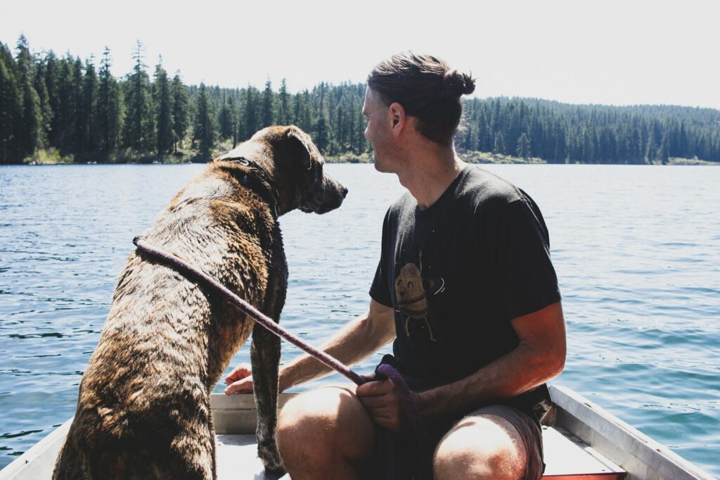 Man and dog on lake in boat