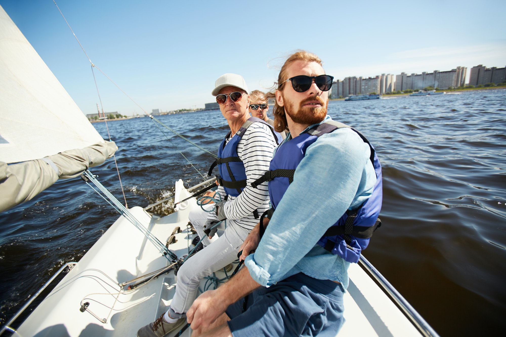Men in life jackets sitting on yacht