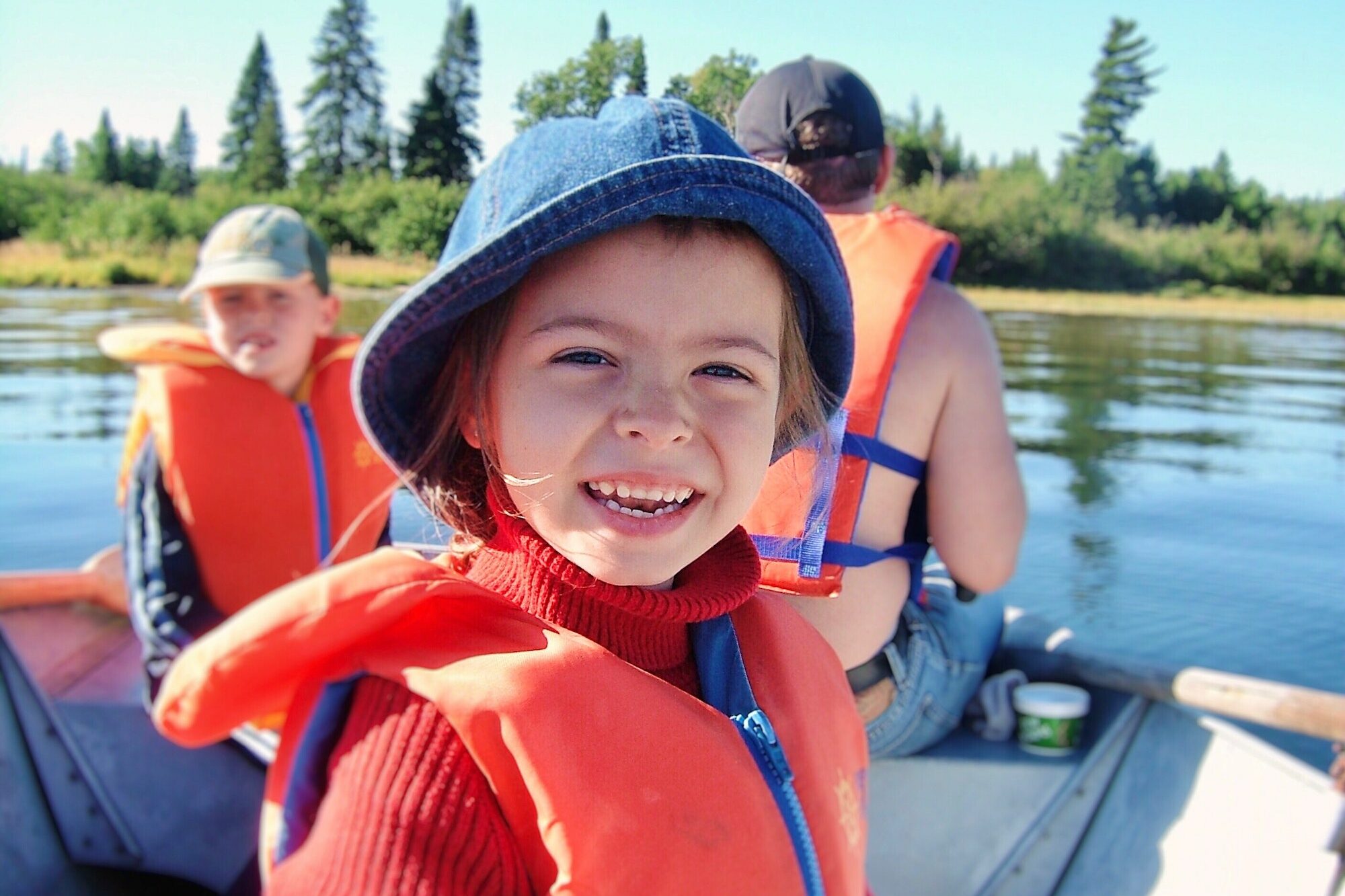 Portrait of little girl smiling while with family on a boat on lake fishing