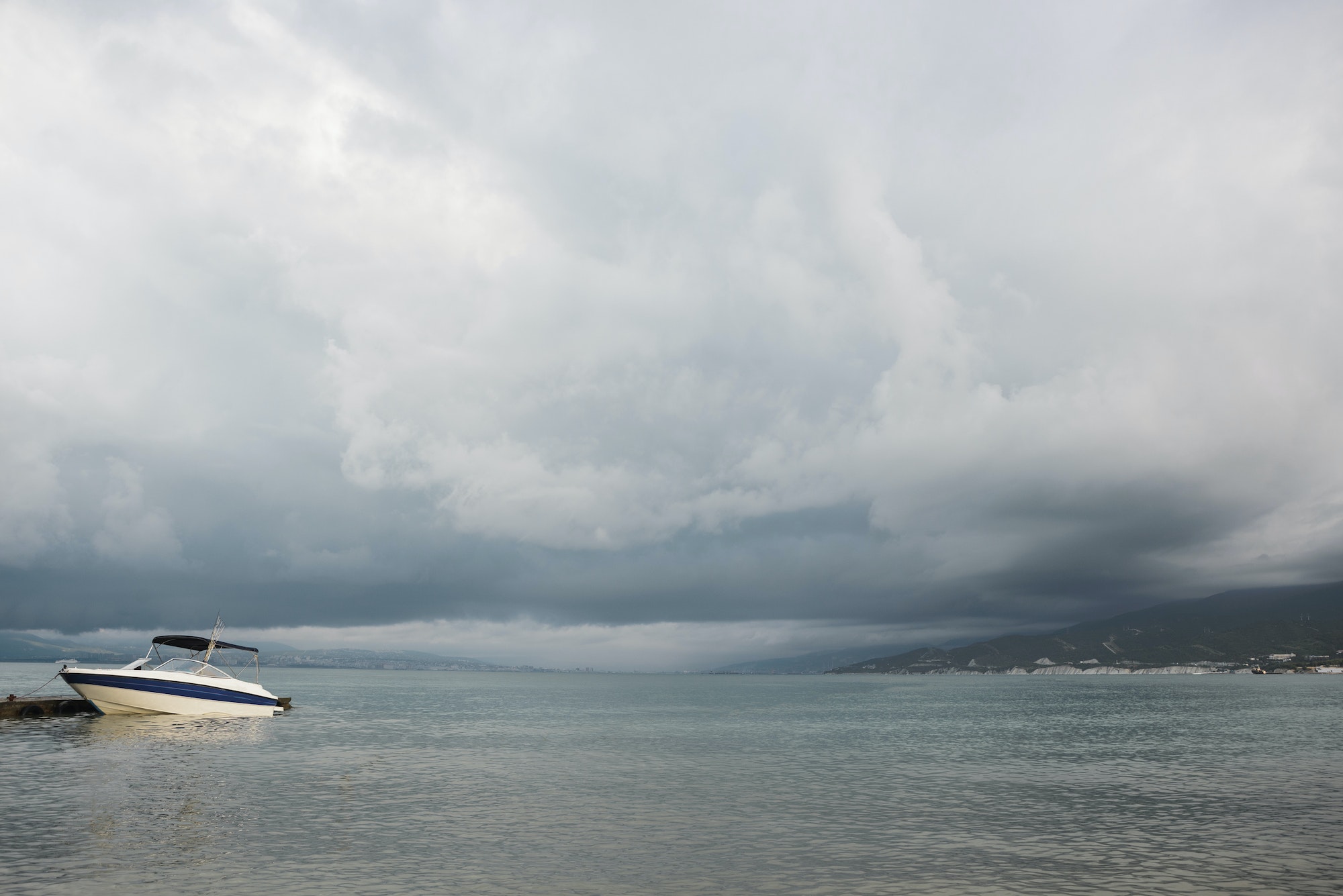 small sport fishing white boat on approaching storm background