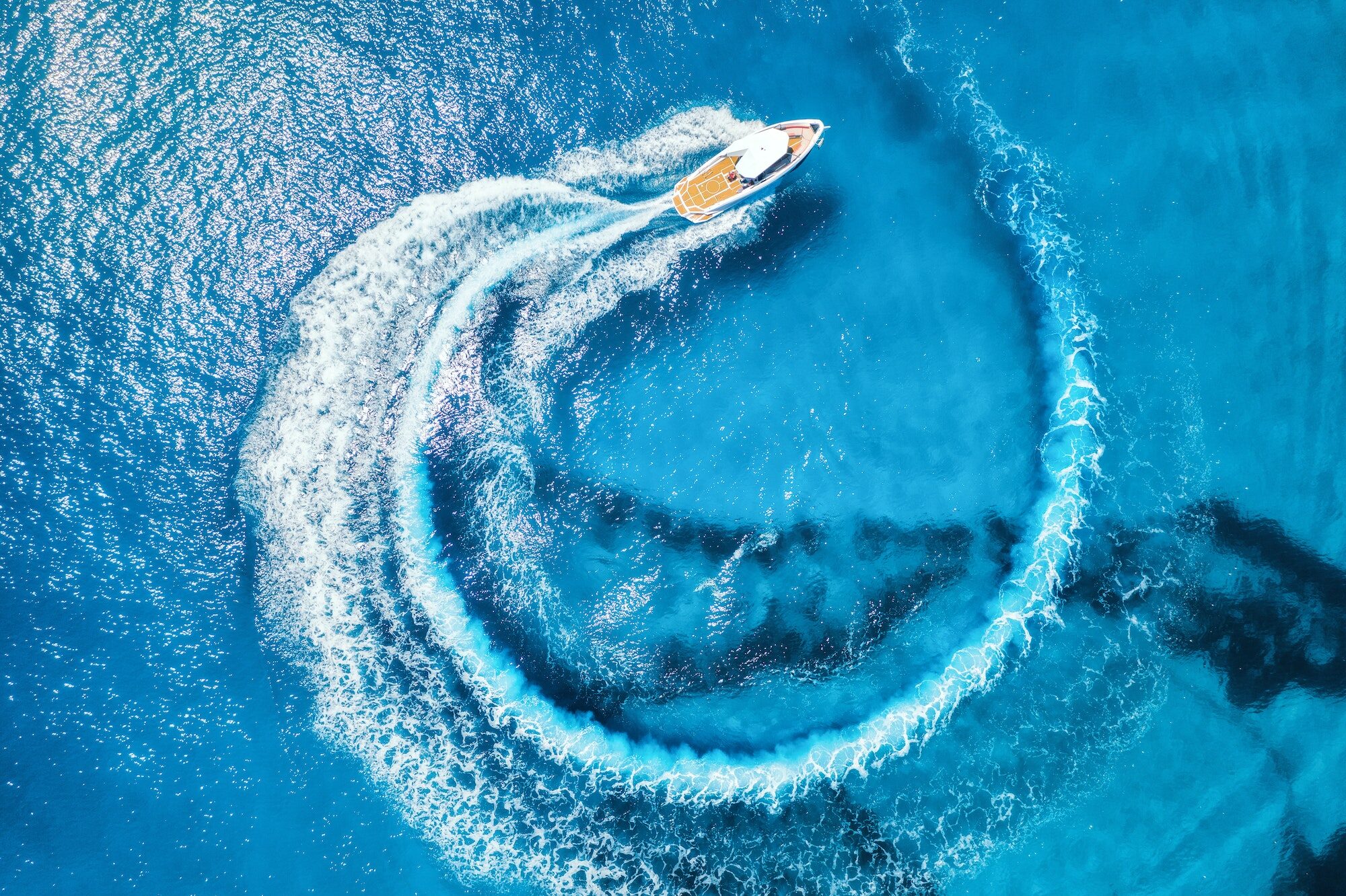 Aerial view of the speed boat in clear blue water at sunny day
