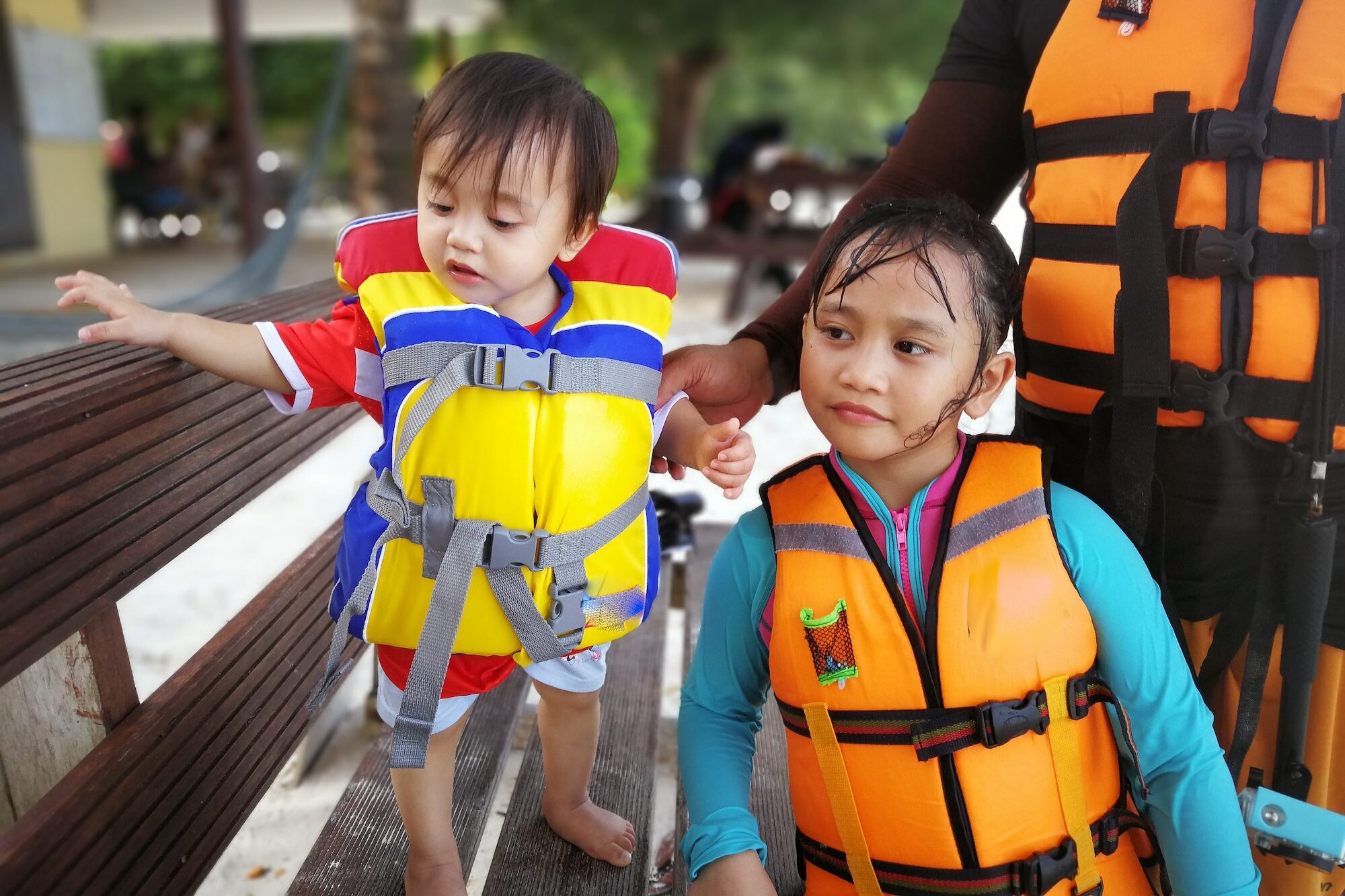 children wearing life jackets on vacation to an island before entering a boat for island hopping