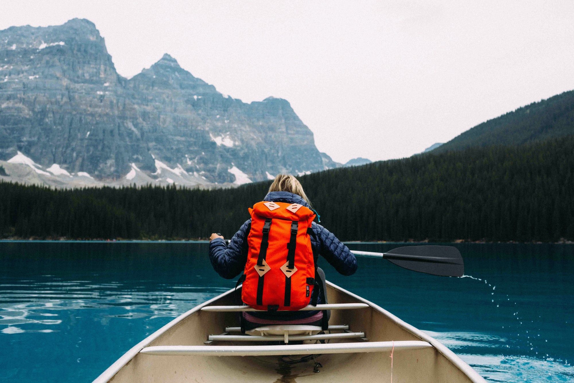 Rear view of mid adult woman paddling canoe, Moraine lake, Banff National Park, Alberta Canada
