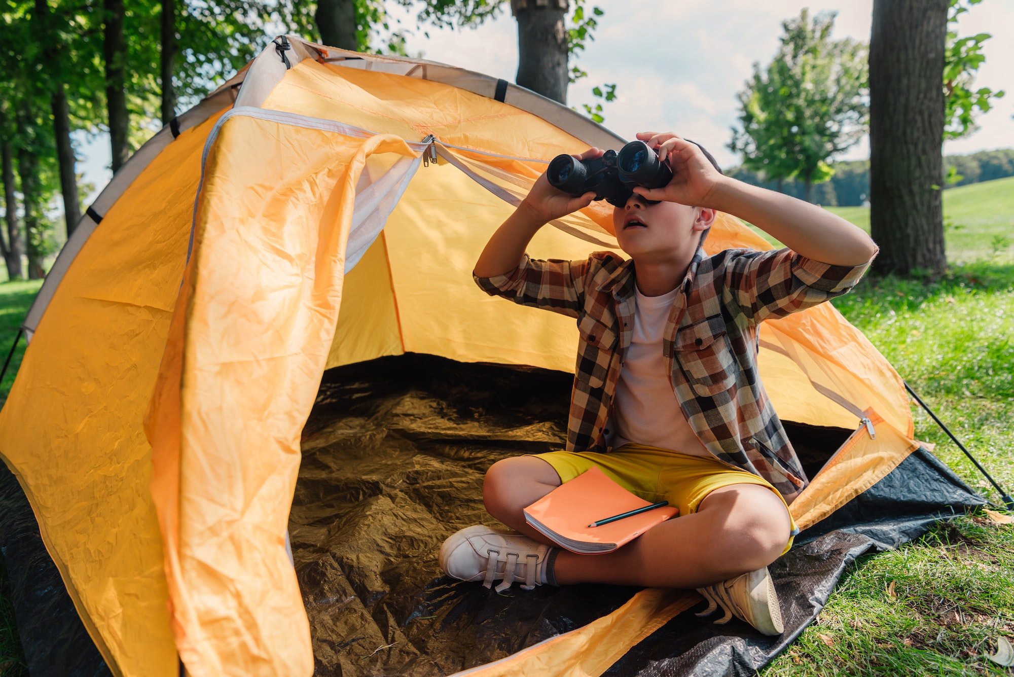 surprised kid looking through binoculars in camp