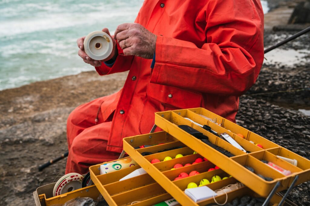 Fisherman with fishing equipment box.