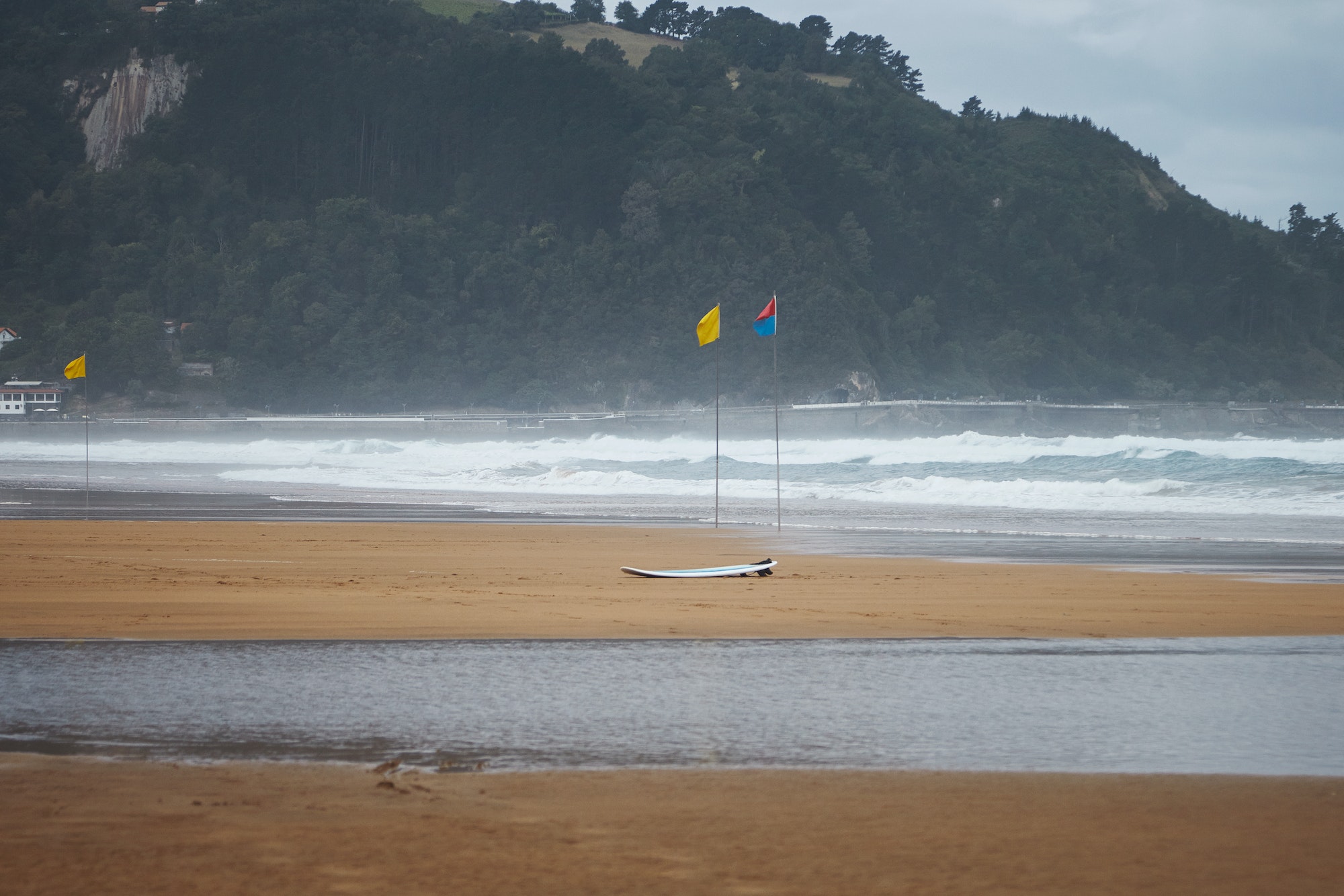 Flags and a surfboard on beach