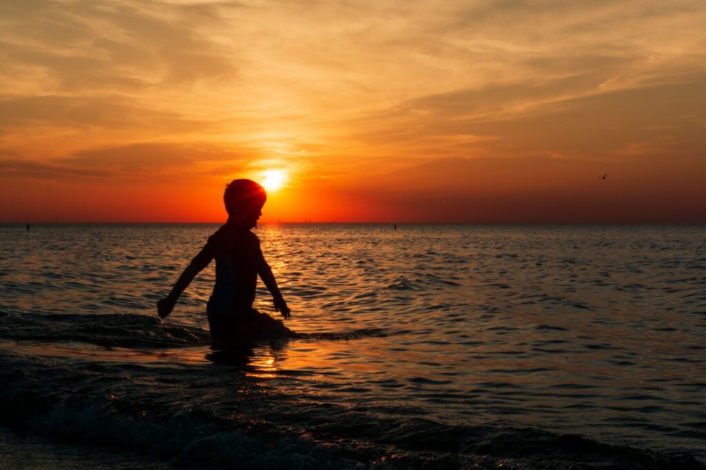 Silhouette of a boy playing in Lake Michigan at sunset