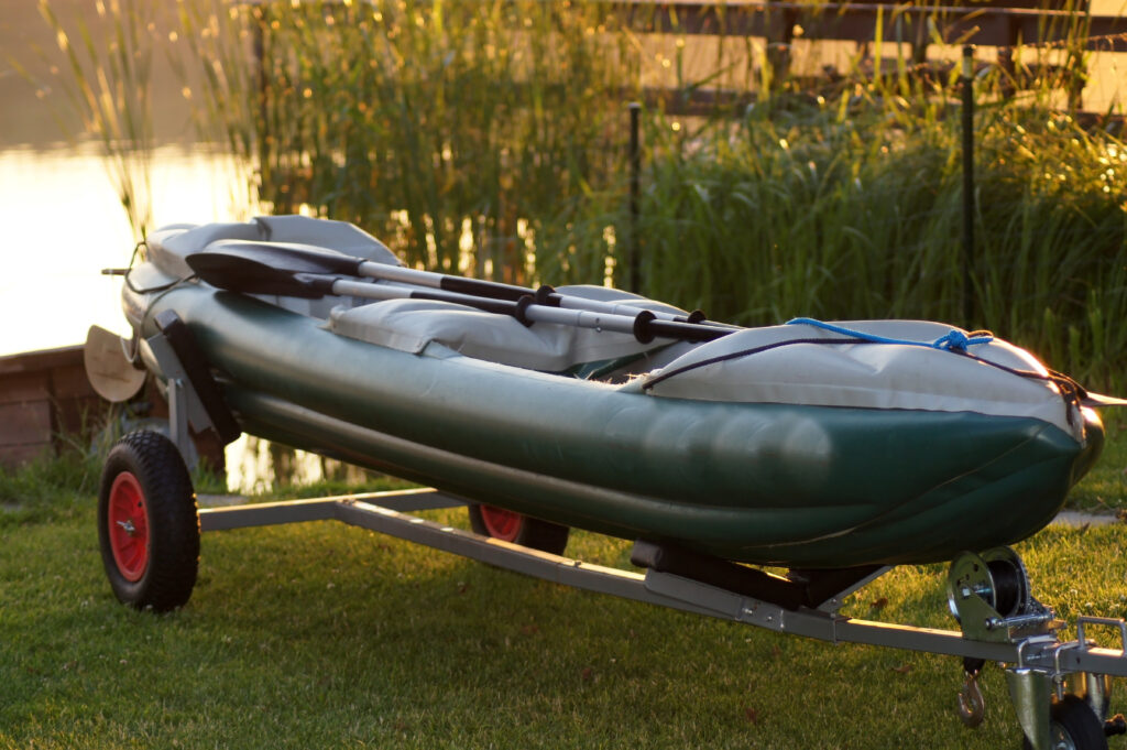 Canoe inflatable boat on boat trailer by the lake